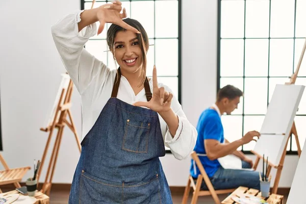 Giovane Coppia Ispanica Studio Arte Sorridente Facendo Cornice Con Mani — Foto Stock