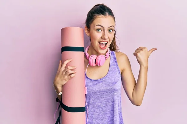 Genç Esmer Kadın Yoga Minderini Tutuyor Başparmağını Yana Kaldırıyor Ağzı — Stok fotoğraf