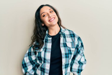 Yüzünde mutlu ve havalı bir gülümseme olan gündelik kıyafetler giyen güzel bir ortadoğulu kadın. şanslı kişi. 