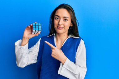 Genç İspanyol kız renkli bulmaca oyunu oynuyor. Zeka küpü zeka oyunu. Gülümsüyor. 