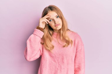 Güzel, genç, beyaz bir kız. Günlük kıyafetler giyiyor. Alnındaki bir sorun yüzünden endişeli ve stresli. 