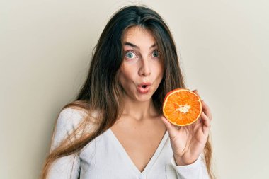 Kafkasyalı genç bir kadın elinde taze bir dilim portakal tutuyor. Korkmuş ve ağzı açık şaşkınlık içinde, inançsız bir yüz. 