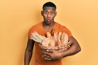 Genç siyahi adam sepeti elinde tutuyor. Korkmuş ve ağzı açık kalmış, şaşırmış, inançsız bir yüz. 
