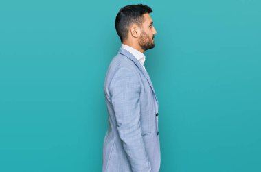 İş ceketi giyen genç İspanyol bir adam profilini gevşetmek için kendine güvenen bir gülümsemeyle doğal bir poz veriyor.. 