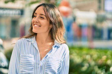 Genç İspanyol kadın gülümseyerek şehirde mutlu mesut dikiliyor..