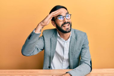 Ofiste çalışan genç İspanyol adam çok mutlu ve gülümsüyor. Çok uzaklara bakıyor. arama kavramı. 