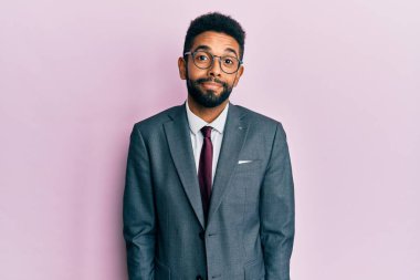 Sakallı, takım elbiseli ve kravatlı yakışıklı bir iş adamı. Gülümsüyor ve başka tarafa bakıyor.. 