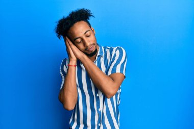 Sakallı, sıradan çizgili gömlek giyen, yorgun uyuyan, hayal kuran, elleri ve gözleri kapalı gülümseyen genç Afrikalı Amerikalı adam.. 