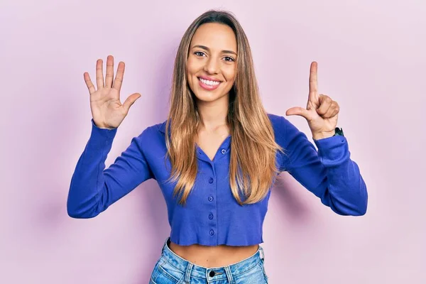 自信と幸せ笑顔ながら カジュアルなブルーのシャツを着て 指の番号7で見上げ美しいヒスパニック女性 — ストック写真