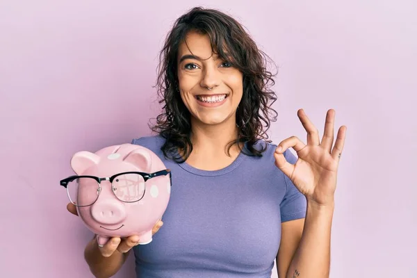 Jeune Femme Hispanique Tenant Tirelire Avec Des Lunettes Faisant Signe — Photo