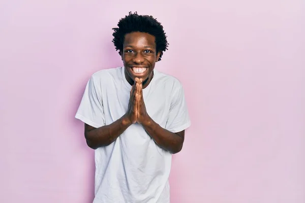 Fiatal Afro Amerikai Férfi Alkalmi Fehér Pólóban Kéz Kézben Imádkozva — Stock Fotó