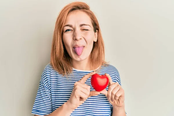 Joven Mujer Caucásica Sosteniendo Corazón Sacando Lengua Feliz Con Expresión — Foto de Stock