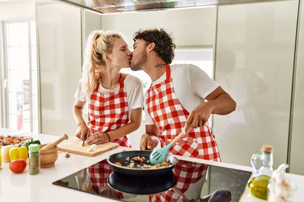 若いですカップル接吻と調理にフライパンでキッチン — ストック写真