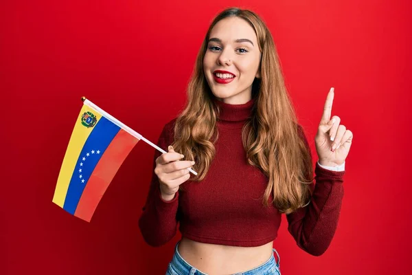 Fiatal Szőke Kezében Venezuelai Zászló Mosolyog Egy Ötlettel Vagy Kérdéssel — Stock Fotó