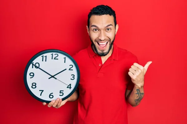 Homme Hispanique Avec Barbe Tenant Grande Horloge Pointant Pouce Vers — Photo