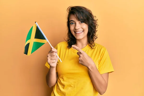 Jovem Hispânica Segurando Bandeira Jamaica Sorrindo Feliz Apontando Com Mão — Fotografia de Stock
