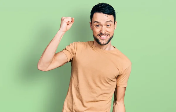 髭を生やしたヒスパニック系の男が幸せと陽気に踊るカジュアルTシャツを着て 笑顔で移動カジュアルで自信を持って音楽を聴く — ストック写真