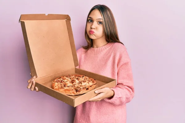 若いブルネットの女性は面白い顔でイタリアのピザパフ頬を保持しています 空気を吸い込み空気を吸い込み — ストック写真