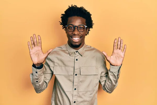 自信と幸せ笑顔ながら 若いアフリカ系アメリカ人の男性は カジュアルな服や眼鏡を着て指の数10で示すと指摘します — ストック写真