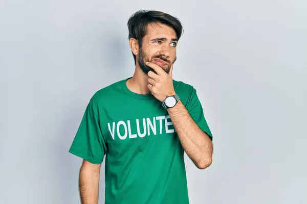 Jovem Hispânico Vestindo Camiseta Voluntária Pensando Preocupado Com Uma Pergunta — Fotografia de Stock
