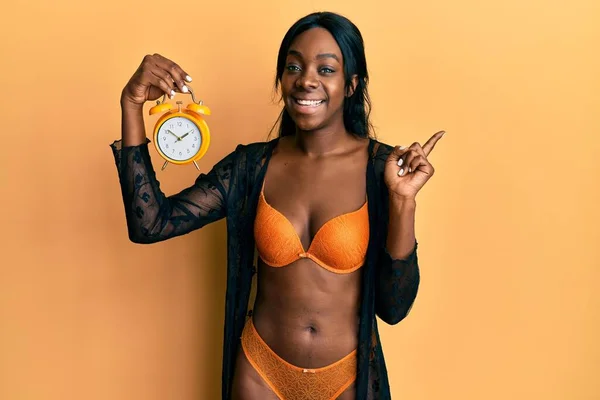Genç Afro Amerikalı Kadın Çamaşırı Giyip Çalar Saat Tutuyor Mutlu — Stok fotoğraf