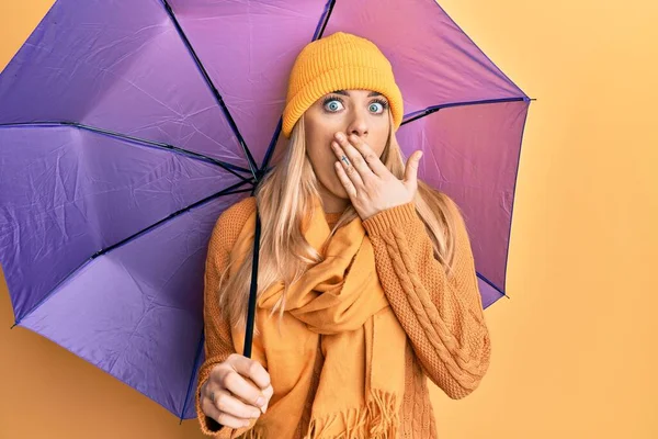 若い白人女性が手で口をカバー紫色の傘を保持し ショックを受け 間違いを恐れている 驚きの表情 — ストック写真