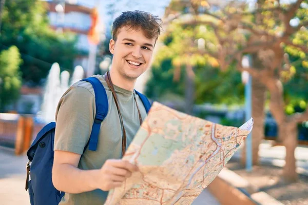 年轻的高加索游客开心地笑着拿着地图看着城市 — 图库照片