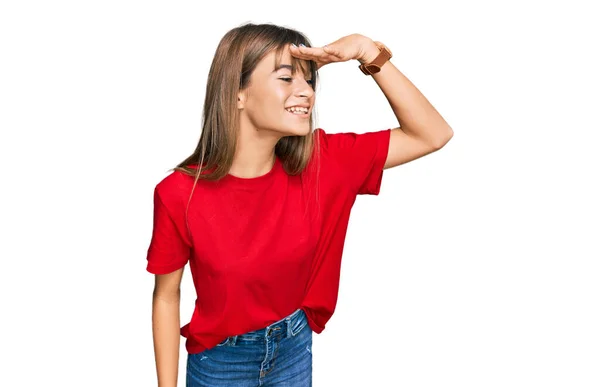 十代の白人の女の子は カジュアルな赤いTシャツを着て非常に幸せと笑みを浮かべて遠くに手を頭の上に見て 検索の概念 — ストック写真