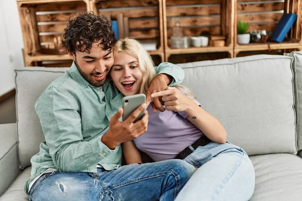 Casal Jovem Usando Smartphone Sentado Sofá Casa — Fotografia de Stock