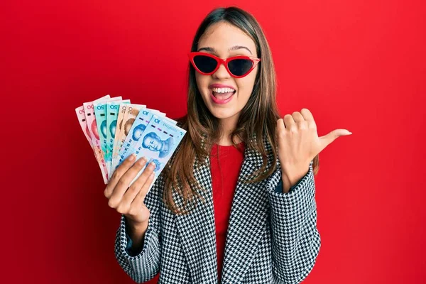 Jovem Morena Segurando Yuan Chinês Notas Apontando Polegar Até Lado — Fotografia de Stock