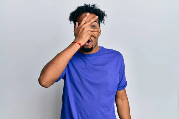 Mladý Afroameričan Plnovousem Sobě Nenucené Modré Tričko Vykukující Šoku Zakrývající — Stock fotografie