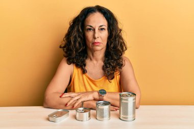 Konserve yiyecekleri olan, aklı başında, aklı başında, kendine güvenen orta yaşlı güzel bir kadın. 