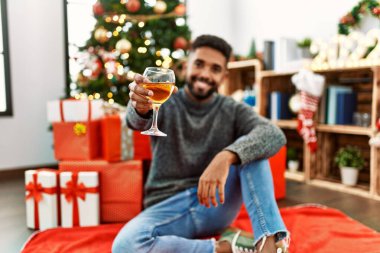 Genç Afrikalı Amerikalı adam gülümsüyor. Mutlu noeller, evde şampanya içiyor..