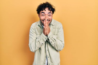 Gündelik kıyafetler giyen genç İspanyol adam elleriyle dua ediyor af diliyor kendinden emin bir şekilde gülümsüyor.. 