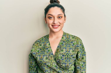 Yüzünde mutlu ve havalı bir gülümseme olan gündelik kıyafetler giyen güzel bir ortadoğulu kadın. şanslı kişi. 