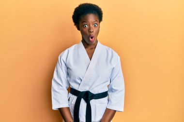 Karate kimonosu ve siyah kuşak giyen Afrikalı genç bir kız. Şaşırtıcı bir ifade, korku ve heyecanlı bir yüz ifadesiyle korkmuş ve şok olmuştu.. 