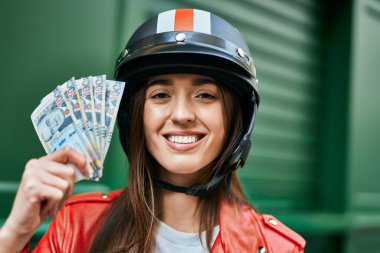 Moto başlık takan ve şehirde Peru sol banknotları tutan genç İspanyol kadın..