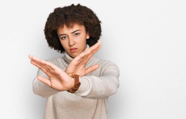 Kışın yün süveter giyen genç İspanyol kız kollarını kavuşturup, avuç içlerini bozarken, kızgın yüz ifadesi takınıyor. 