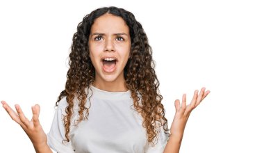 Gündelik beyaz tişört giyen genç İspanyol kız deli gibi bağırıyor ve agresif bir ifade ve kollarla bağırıyor. hüsran kavramı. 