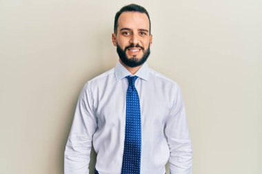 Sakallı, iş kravatlı, yüzünde güzel bir gülümseme olan genç bir adam. şanslı kişi. 