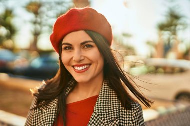 Genç İspanyol kadın gülümseyerek şehirde mutlu mesut dikiliyor..