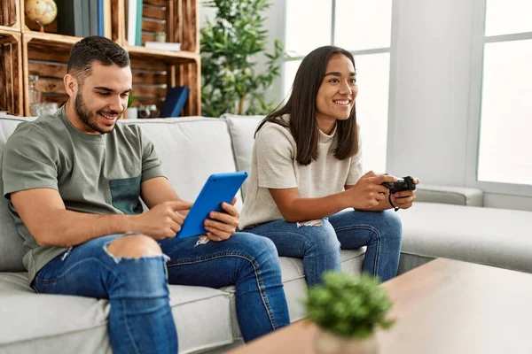 Νεαρό Λατινικό Ζευγάρι Παίζει Βιντεοπαιχνίδι Και Χρησιμοποιεί Touchpad Στο Σπίτι — Φωτογραφία Αρχείου