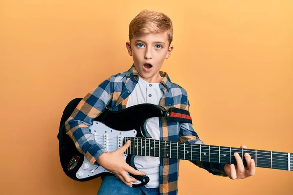 Pequeno Garoto Caucasiano Tocando Guitarra Elétrica Rosto Choque Parecendo Cético — Fotografia de Stock