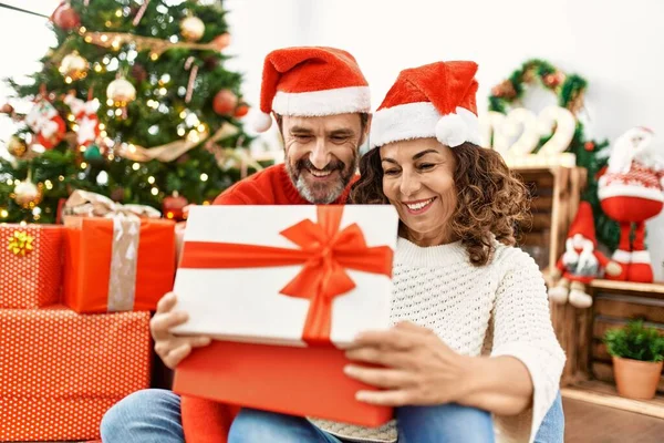 Középkorú Spanyol Pár Karácsonyi Kalapban Padlón Nyitó Ajándék Otthon — Stock Fotó
