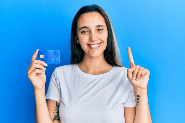 Joven Mujer Hispana Sosteniendo Tarjeta Crédito Sonriendo Con Una Idea —  Fotos de Stock