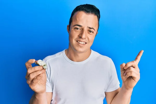 Handsome Young Man Holding Raw Oyster Smiling Happy Pointing Hand — Stock Photo, Image