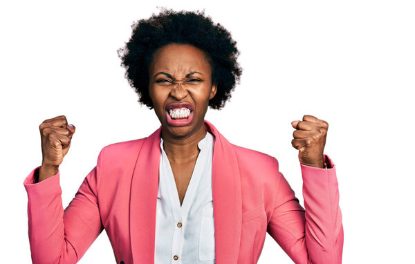 African american woman with afro hair wearing business jacket angry and mad raising fists frustrated and furious while shouting with anger. rage and aggressive concept. 