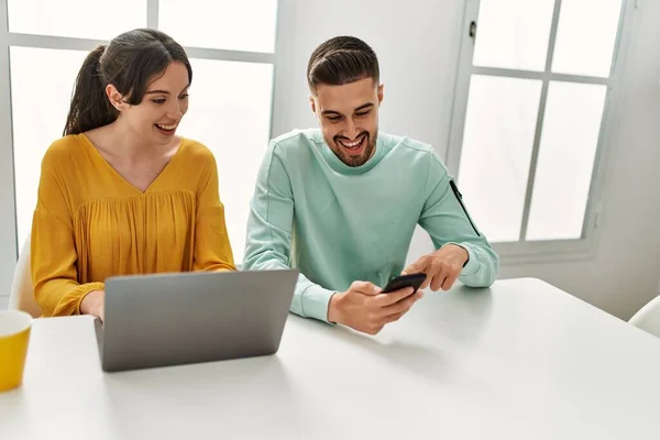 Jovem Casal Hispânico Usando Laptop Smartphone Bebendo Café Casa — Fotografia de Stock