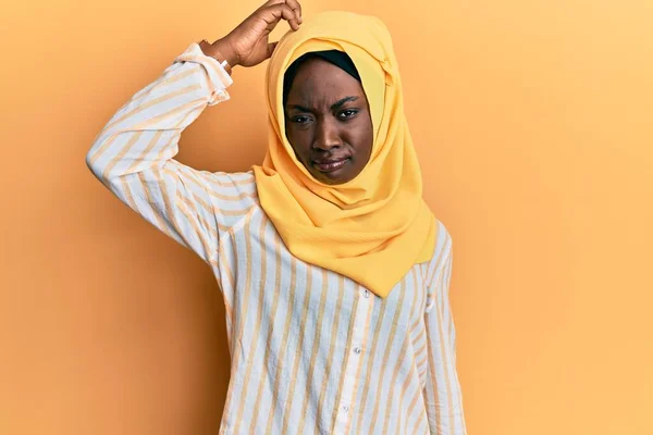 伝統的なイスラム教のヒジャーブスカーフを身に着けている美しいアフリカの若い女性は混乱し 質問について不思議 疑いもなく頭に手を置いて考える 包括的な概念は — ストック写真