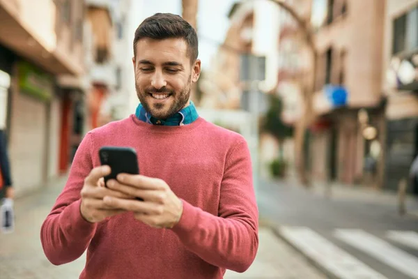 Jonge Spaanse Man Glimlacht Gelukkig Met Behulp Van Smartphone Stad — Stockfoto